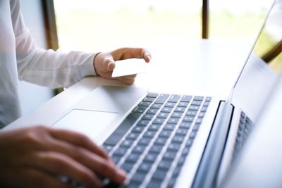 Midsection of woman doing online shopping through laptop