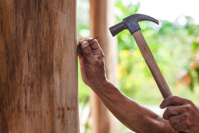 Man hammering nail on wood