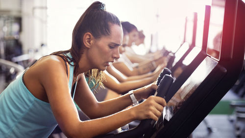 Side view of young woman doing exercise in gym