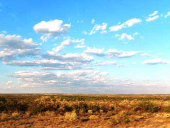 Scenic view of field against cloudy sky