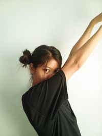 Portrait of young woman standing against white background