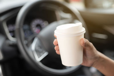 Close-up of hand holding coffee cup