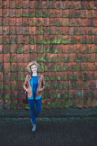 Woman standing against brick wall