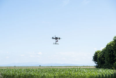 Professional drone flying in a sunny day, above natural landscape.