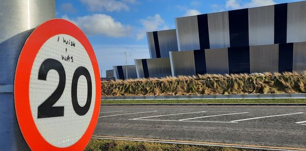 Road sign against sky in city