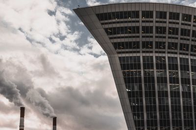 Low angle view of smoke emitting from factory against sky
