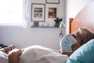 Midsection of woman lying on bed at home