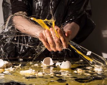 Midsection of person smashing eggs