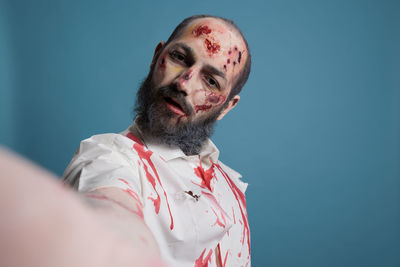 Low angle view of young man against blue background