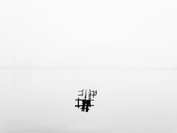 Lone boat on calm lake against clear sky