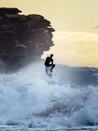 Rear view of men doing water surfing