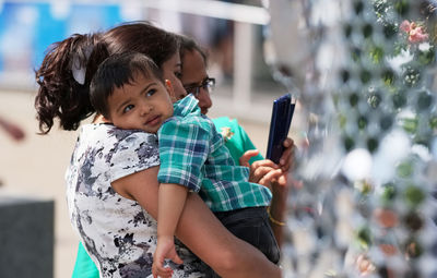 Rear view of woman holding mobile phone