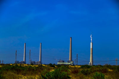 Low angle view of factory against blue sky