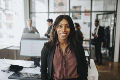 Portrait of smiling businesswoman wearing blazer at office