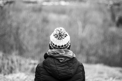 Rear view of man wearing hat on field during winter