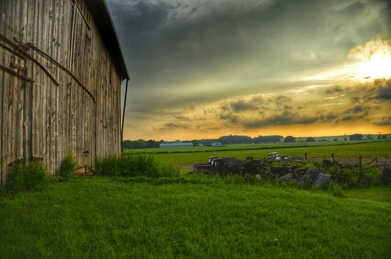 sky, field, grass, landscape, cloud - sky, rural scene, tranquil scene, tranquility, scenics, sunset, cloudy, built structure, nature, grassy, beauty in nature, agriculture, architecture, cloud, green color, farm