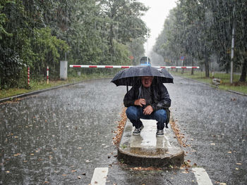 Man on road in the rain