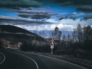 Rear view of man walking on road against sky