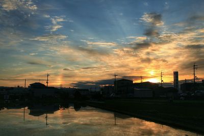 Silhouette of built structure against cloudy sky at sunset