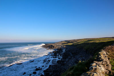Scenic view of sea against clear blue sky