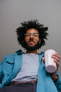 Low angle portrait of man holding coffee