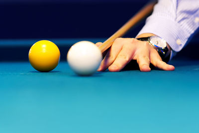 Cropped hand of man playing pool