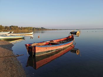 Boat moored in lake against sky