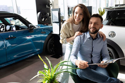 Man and woman looking away in car showroom