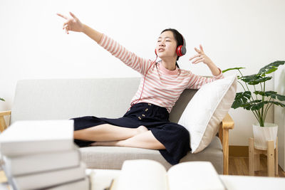 Young woman sitting on sofa at home