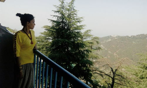 Woman standing on tree trunk