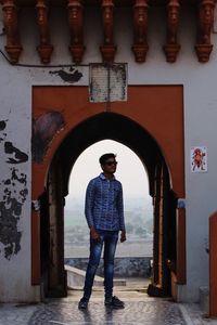 Full length portrait of smiling standing against building