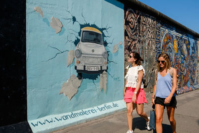 Woman with graffiti on wall