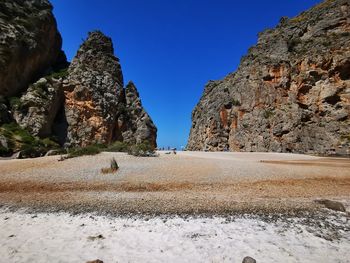 Surface level of rocks against clear blue sky