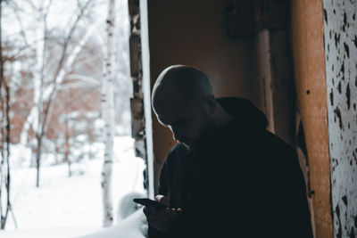 Man looking at camera while standing in snow
