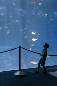 Side view of silhouette man standing by railing