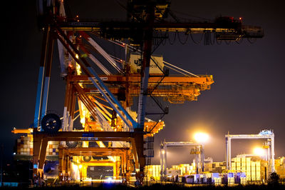 Illuminated commercial dock against sky at night