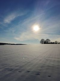 Scenic view of snow covered land against sky during winter