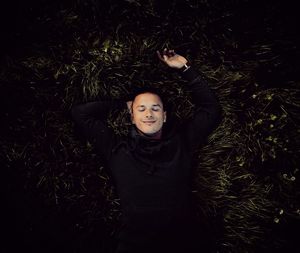 High angle view of smiling man sleeping on grassy field