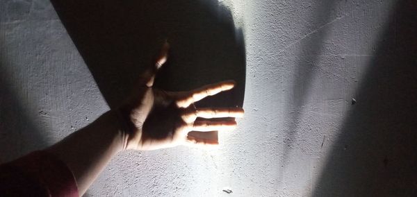 Close-up of hand touching wall