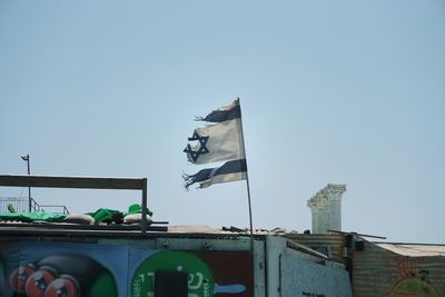 Low angle view of flag on building against clear sky