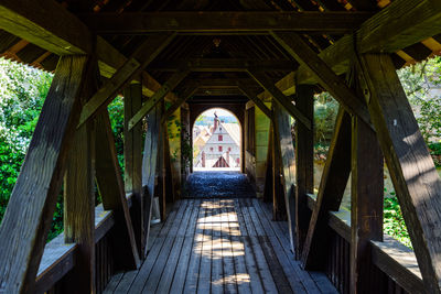 Empty footbridge amidst buildings