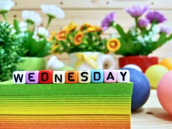 Close-up of colorful blocks with wednesday text on stacked papers over table