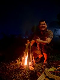 Man sitting beside bonfire