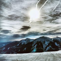 Scenic view of snow covered mountain against cloudy sky