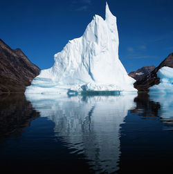 Iceberg floating in still fjord in east greenland