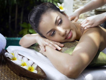 Cropped hands of woman massaging customer at poolside