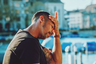 Portrait of young man smoking cigarette in city