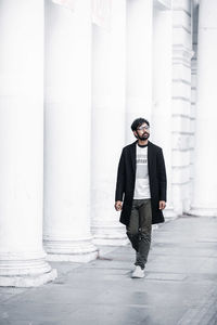 Full length of young man standing against wall