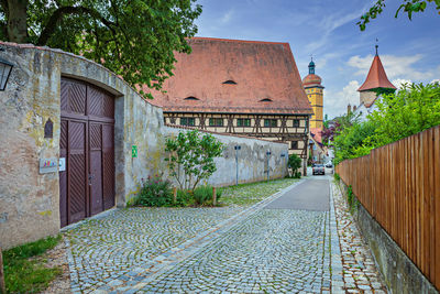 Footpath amidst buildings against sky