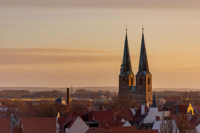 Aerial view of buildings in city against sky during sunset